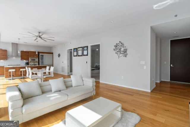 living room with ceiling fan and light hardwood / wood-style floors