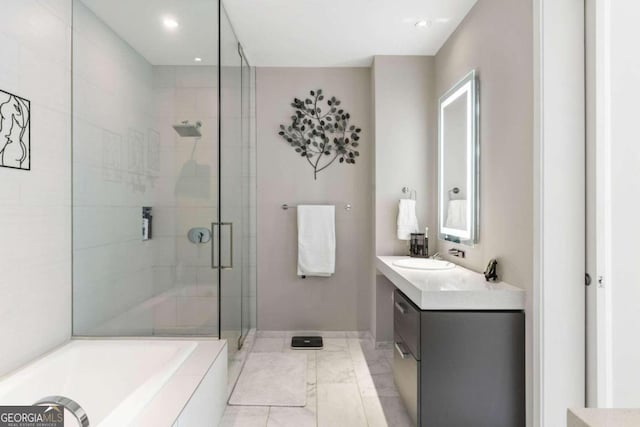 bathroom with a garden tub, a stall shower, recessed lighting, baseboards, and vanity