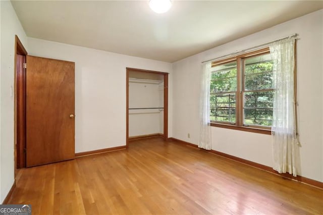 unfurnished bedroom featuring a closet, baseboards, and wood finished floors