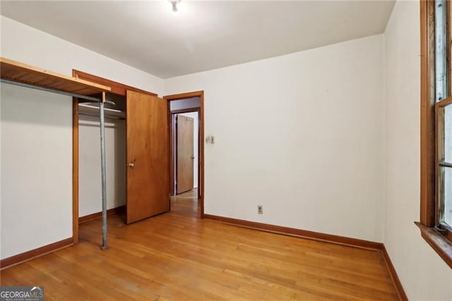 unfurnished bedroom featuring light wood-type flooring and a closet