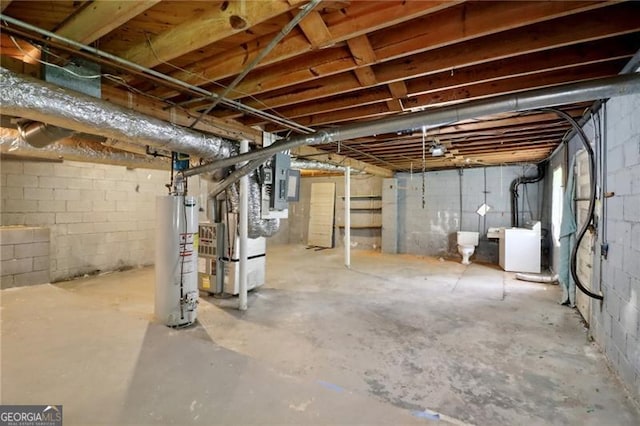 unfinished below grade area featuring electric panel, washer / clothes dryer, water heater, and heating unit