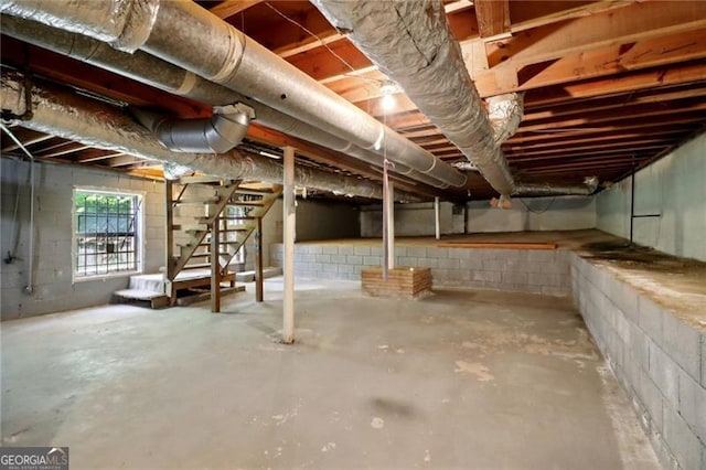 basement with concrete block wall and stairway