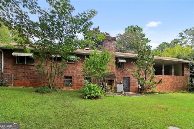 back of property featuring central air condition unit and a lawn