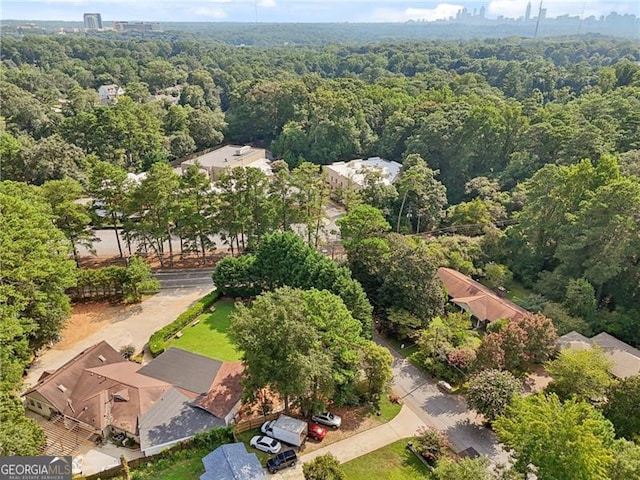 bird's eye view with a wooded view