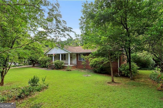view of front of home with covered porch, a front lawn, and brick siding