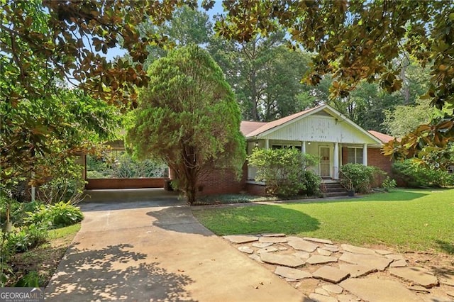 view of front of house with a front yard, covered porch, and concrete driveway