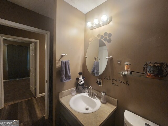 bathroom featuring toilet, hardwood / wood-style floors, and vanity