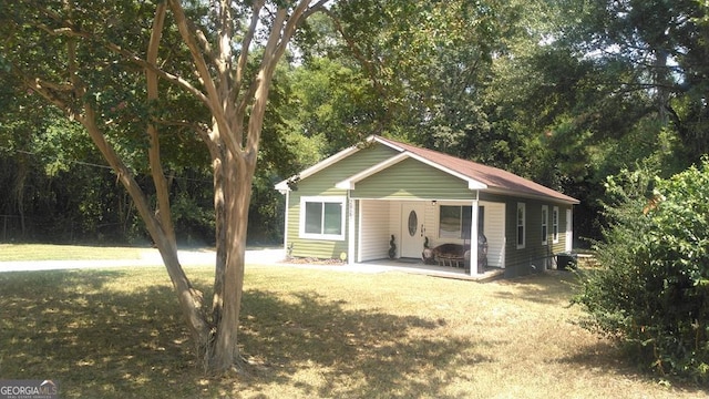 rear view of house with a lawn and an outdoor structure