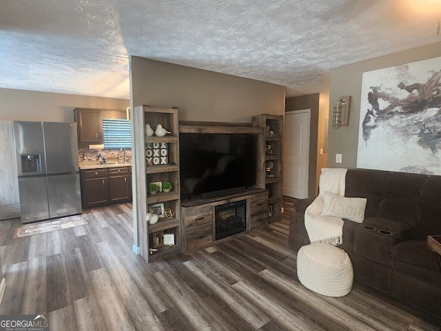 living room featuring hardwood / wood-style flooring, sink, and a textured ceiling