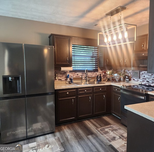 kitchen featuring backsplash, sink, dark brown cabinetry, range with electric cooktop, and fridge with ice dispenser