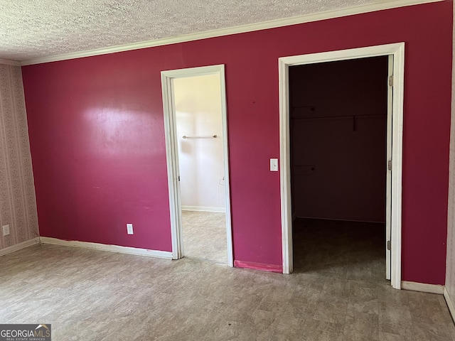 spare room with carpet floors, ornamental molding, and a textured ceiling