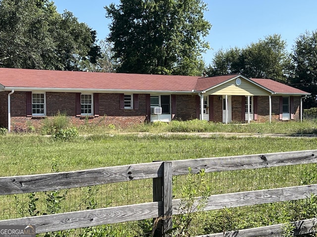 ranch-style home featuring a front lawn and cooling unit