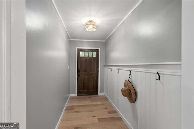 entryway featuring light wood-type flooring and crown molding