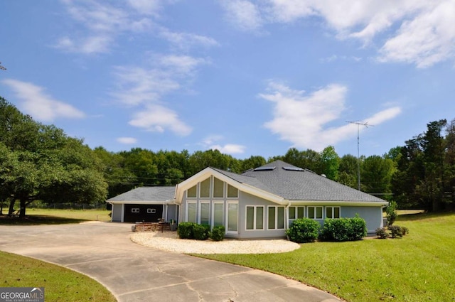 view of front of home featuring an attached garage, driveway, and a front yard