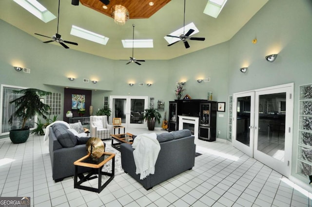 living area featuring light tile patterned floors, high vaulted ceiling, french doors, and a skylight