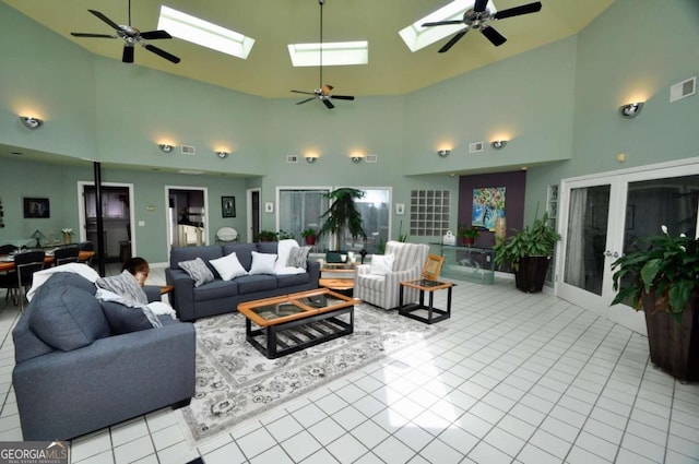 tiled living area with a skylight, ceiling fan, and visible vents