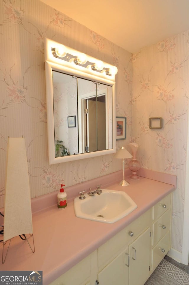 bathroom featuring vanity and wallpapered walls