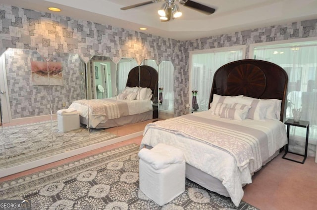 bedroom with wallpapered walls, ceiling fan, a raised ceiling, and recessed lighting