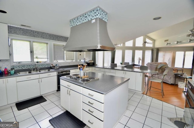 kitchen with a sink, a peninsula, light tile patterned floors, and island exhaust hood