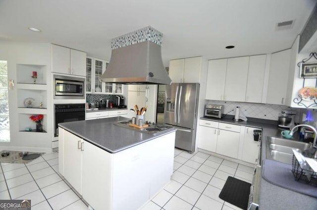 kitchen featuring light tile patterned floors, appliances with stainless steel finishes, a sink, and island range hood