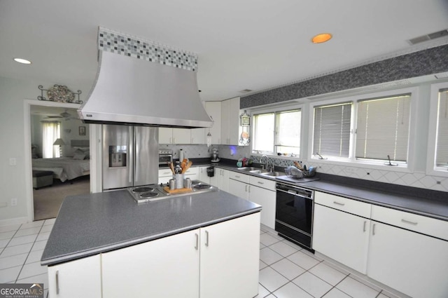 kitchen with dark countertops, appliances with stainless steel finishes, extractor fan, and light tile patterned flooring