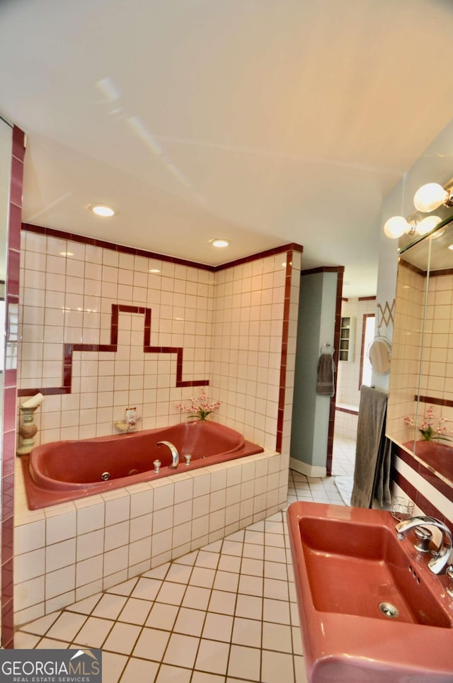 full bathroom featuring a sink, a garden tub, tile patterned flooring, and tile walls