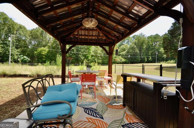 view of patio / terrace with a gazebo, outdoor dining space, and fence