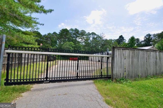 view of gate featuring fence and a lawn