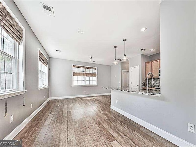 unfurnished living room with sink and dark wood-type flooring