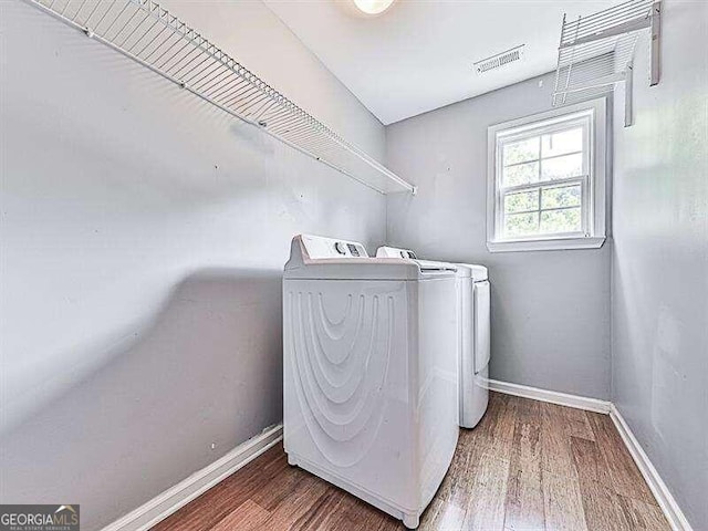 washroom featuring washing machine and clothes dryer and hardwood / wood-style floors