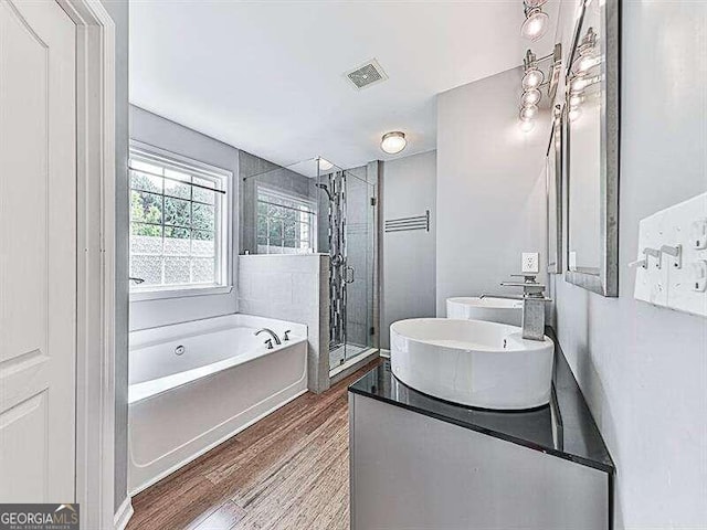 bathroom featuring separate shower and tub, vanity, and hardwood / wood-style floors