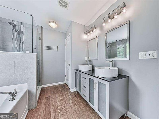 bathroom featuring hardwood / wood-style flooring, shower with separate bathtub, and vanity