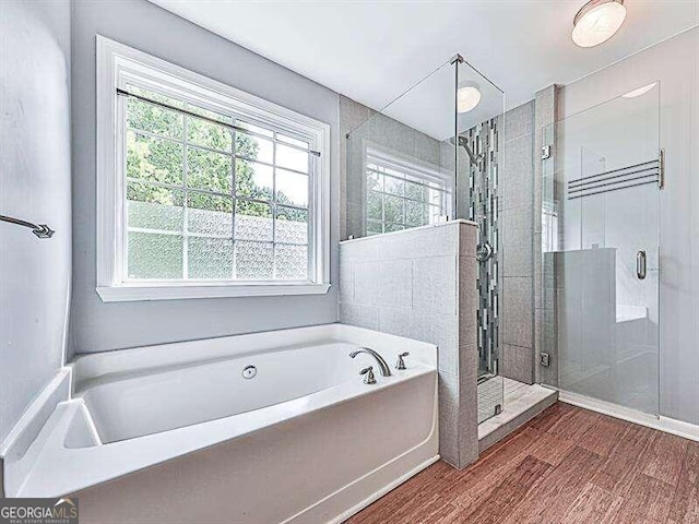 bathroom with hardwood / wood-style floors, a healthy amount of sunlight, and shower with separate bathtub