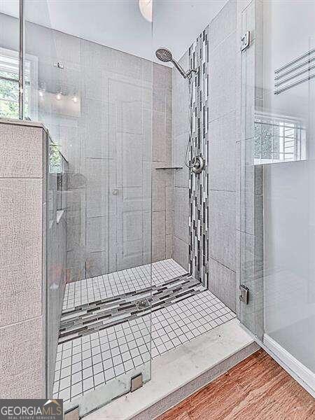 bathroom featuring hardwood / wood-style flooring and walk in shower