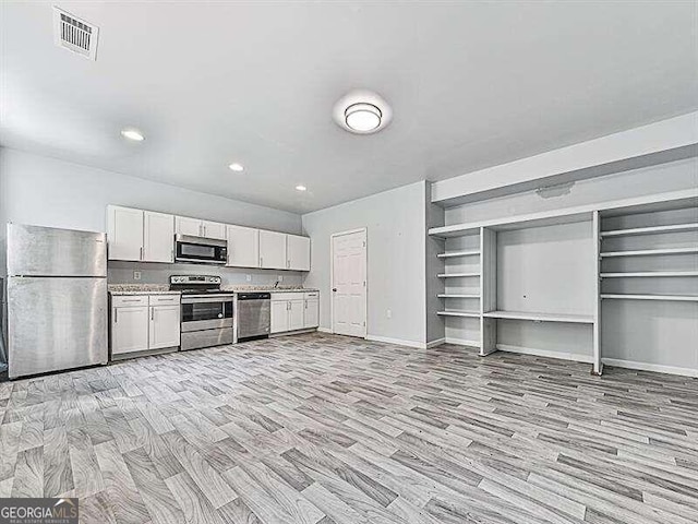 kitchen featuring light wood-type flooring, white cabinetry, and stainless steel appliances