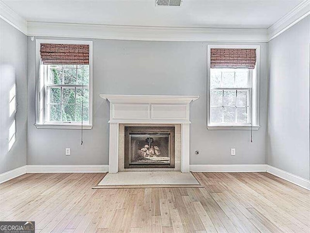 unfurnished living room with light wood-type flooring and ornamental molding