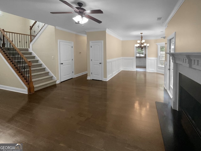 unfurnished living room with dark wood-type flooring, a fireplace with raised hearth, crown molding, and stairway