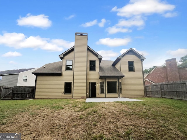 rear view of property with a patio, a lawn, and a fenced backyard