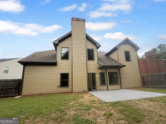 rear view of property featuring a yard, fence, and a patio