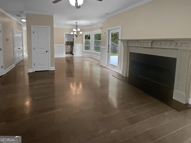 unfurnished living room with ornamental molding, dark wood-style flooring, a fireplace, a decorative wall, and ceiling fan with notable chandelier