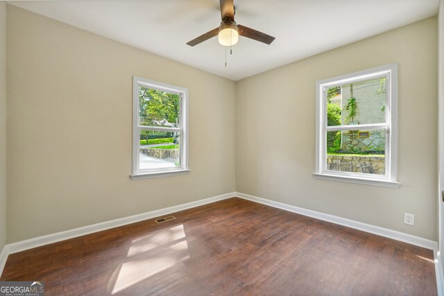 spare room featuring ceiling fan and dark wood-type flooring