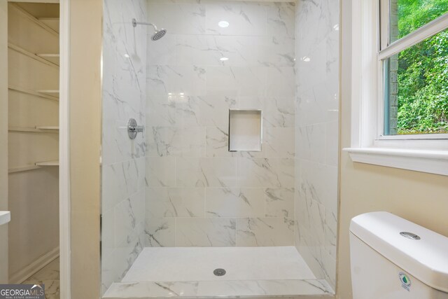 bathroom with toilet and tiled shower