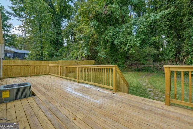 wooden deck with cooling unit and a lawn