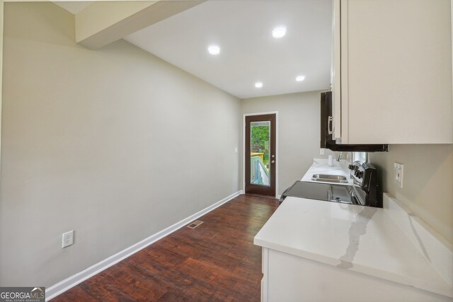 kitchen featuring white cabinets, beamed ceiling, and dark hardwood / wood-style floors