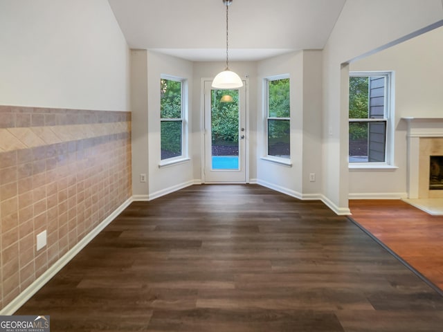 entryway with a healthy amount of sunlight, baseboards, a fireplace with raised hearth, and wood finished floors