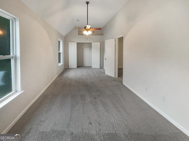 interior space with vaulted ceiling, a ceiling fan, and baseboards