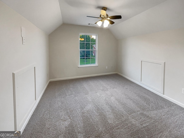 additional living space with ceiling fan, carpet floors, visible vents, baseboards, and vaulted ceiling