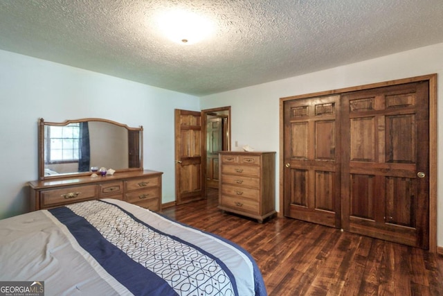 bedroom with a textured ceiling, a closet, and dark hardwood / wood-style floors