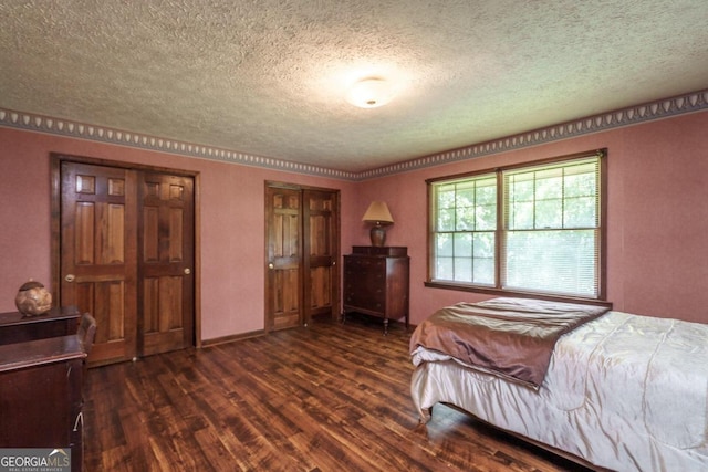 bedroom with dark wood-type flooring and a textured ceiling