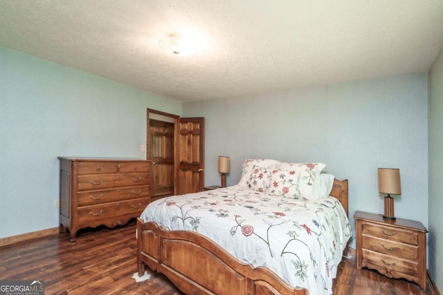 bedroom with a textured ceiling and dark hardwood / wood-style flooring